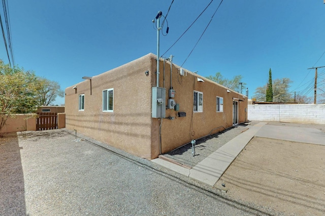 view of home's exterior featuring a patio, stucco siding, and fence