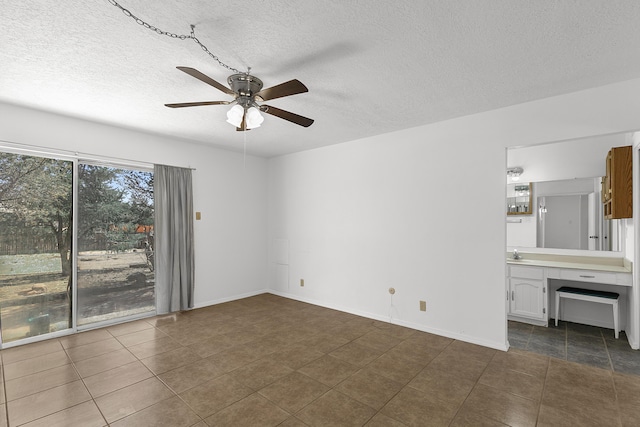 317 Baldwin Ave, Rio Communities, NM 87002 - unfurnished bedroom featuring dark tile patterned floors, a textured ceiling, and ceiling fan