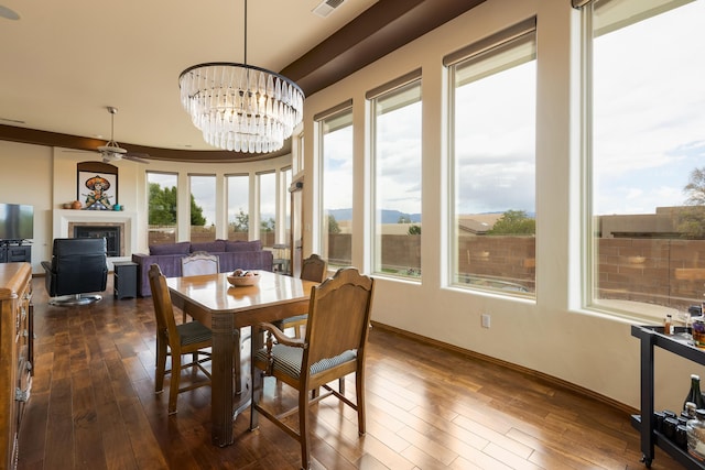 4701 Mi Cordelia Dr NW, Albuquerque, NM 87120 - dining space featuring a glass covered fireplace, dark wood-style flooring, a chandelier, ceiling fan, and baseboards