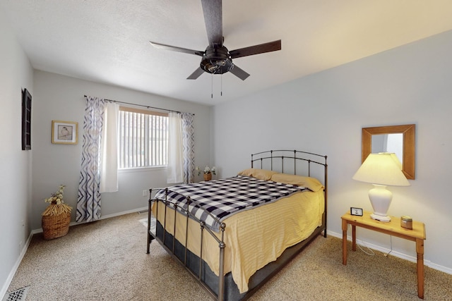 carpeted bedroom with visible vents, baseboards, and a ceiling fan
