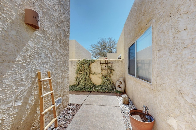 view of home's exterior featuring a patio, stucco siding, and fence