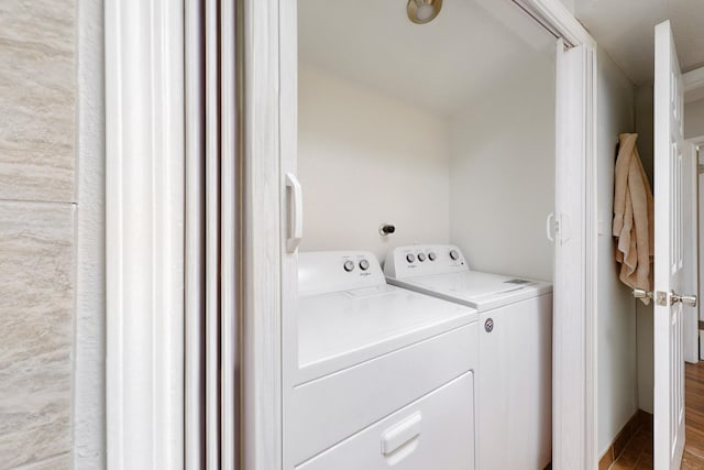 laundry room with washer and dryer, laundry area, and wood finished floors