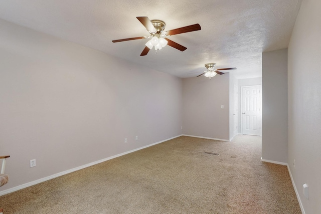 unfurnished room with a textured ceiling, a ceiling fan, visible vents, light carpet, and baseboards