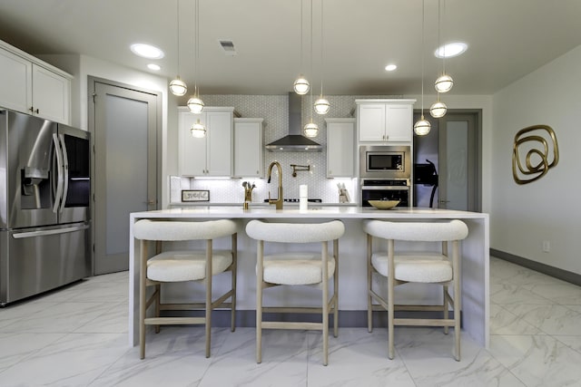 kitchen featuring light countertops, visible vents, wall chimney exhaust hood, appliances with stainless steel finishes, and marble finish floor