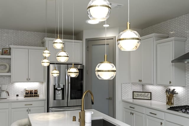 kitchen with tasteful backsplash, wallpapered walls, light countertops, and stainless steel appliances