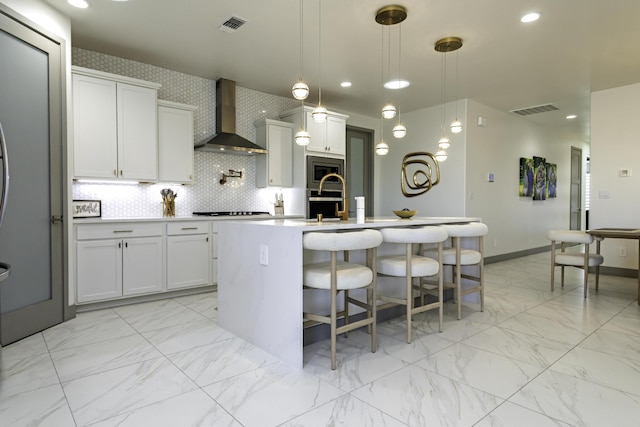kitchen with wall chimney range hood, stainless steel appliances, visible vents, and marble finish floor