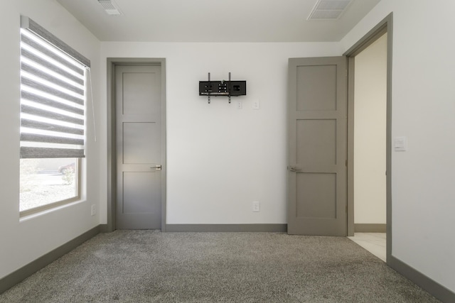 spare room with visible vents, baseboards, and carpet