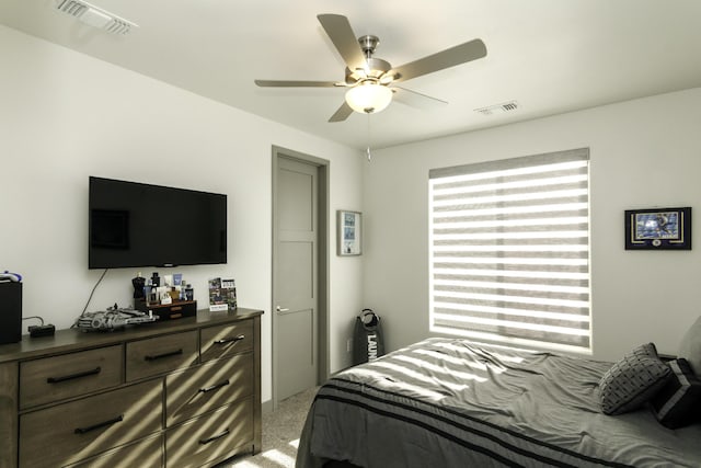 bedroom featuring visible vents, a ceiling fan, and light carpet