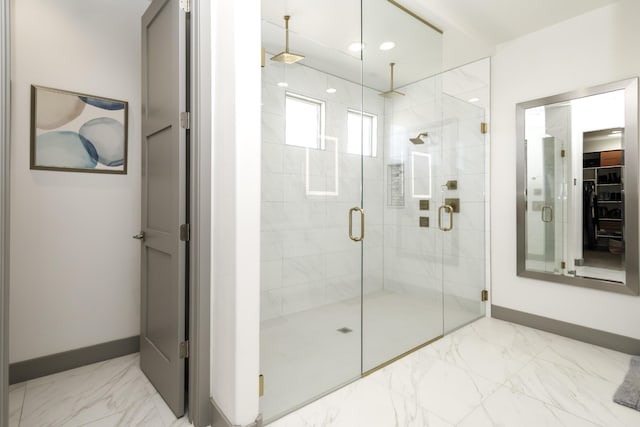 bathroom featuring baseboards, a shower stall, and marble finish floor