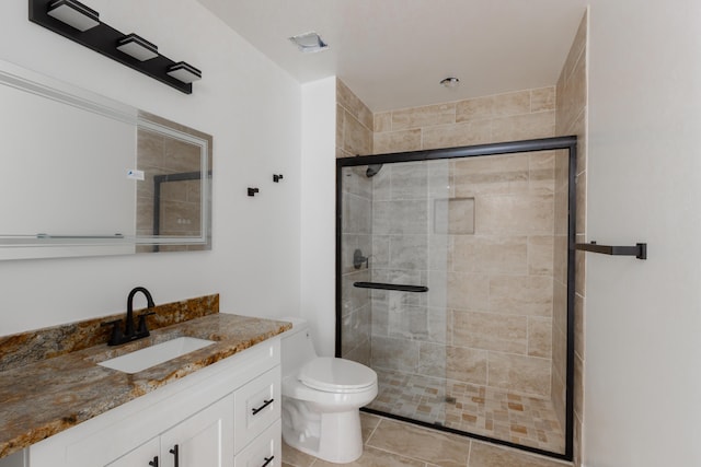 bathroom with vanity, tile patterned flooring, a shower stall, and toilet