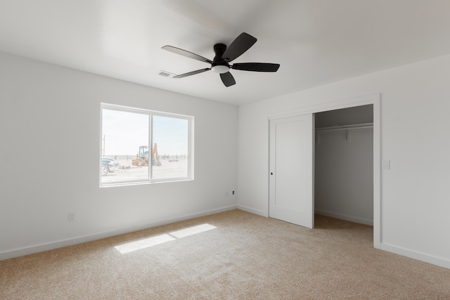 unfurnished bedroom with light carpet, visible vents, baseboards, a ceiling fan, and a closet