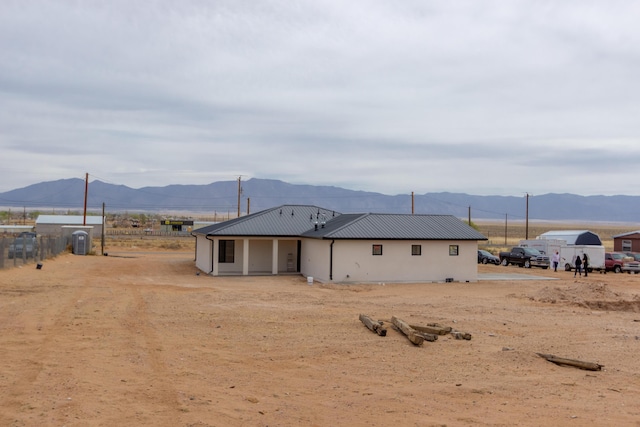 rear view of property featuring cooling unit, metal roof, and a mountain view