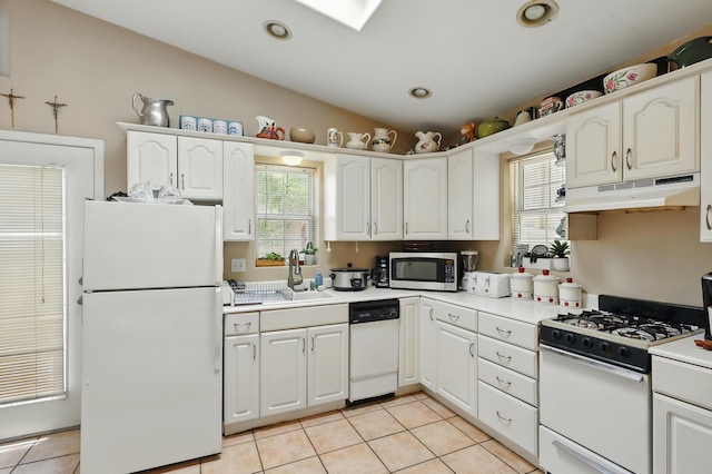 135B Sichler Rd SW, Los Lunas, NM 87031 - kitchen with white appliances, under cabinet range hood, light tile patterned floors, white cabinetry, and light countertops