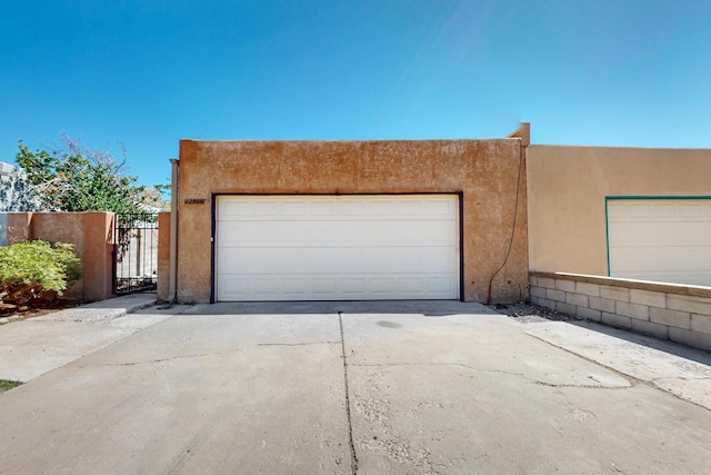 12522 Singing Arrow Ave SE, Albuquerque, NM 87123 - garage featuring driveway and a gate