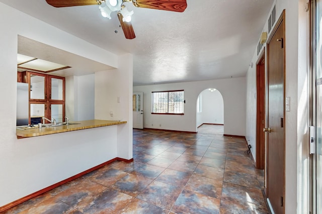 12522 Singing Arrow Ave SE, Albuquerque, NM 87123 - interior space with arched walkways, ceiling fan, baseboards, and a sink