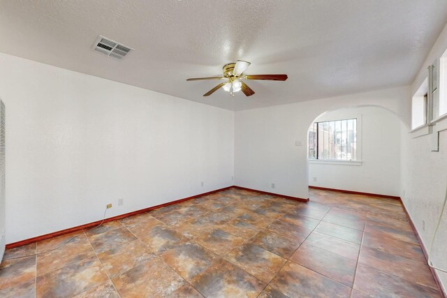 12522 Singing Arrow Ave SE, Albuquerque, NM 87123 - unfurnished room with arched walkways, baseboards, a ceiling fan, and visible vents