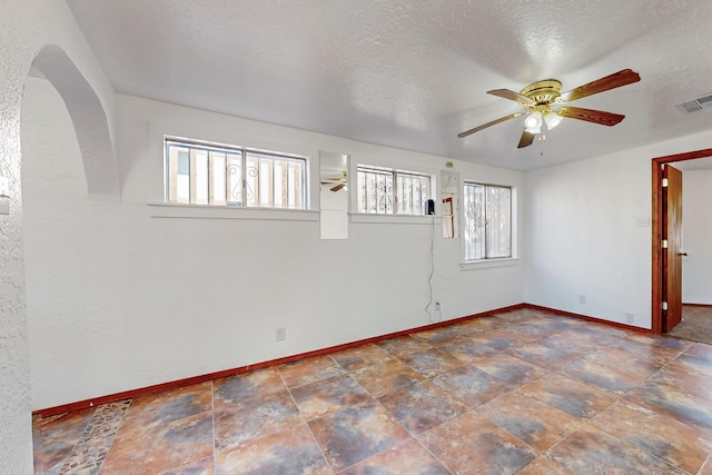 12522 Singing Arrow Ave SE, Albuquerque, NM 87123 - unfurnished room with arched walkways, visible vents, baseboards, and ceiling fan