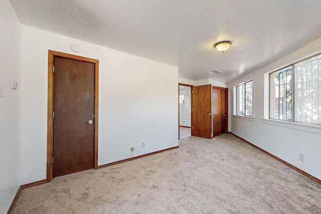 12522 Singing Arrow Ave SE, Albuquerque, NM 87123 - interior space featuring light carpet, visible vents, baseboards, and a textured ceiling