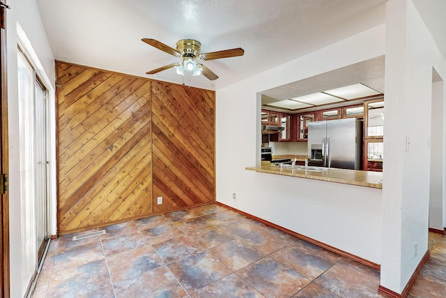 12522 Singing Arrow Ave SE, Albuquerque, NM 87123 - kitchen featuring wooden walls, baseboards, visible vents, and stainless steel appliances