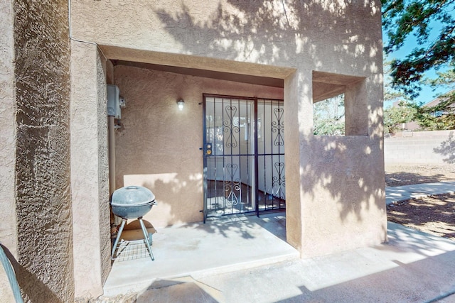 12522 Singing Arrow Ave SE, Albuquerque, NM 87123 - view of exterior entry featuring stucco siding and fence