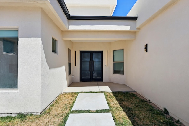 entrance to property featuring french doors and stucco siding