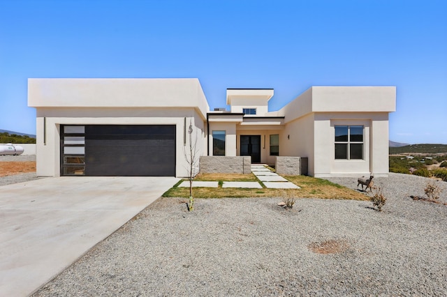 contemporary home with a garage, stucco siding, and concrete driveway