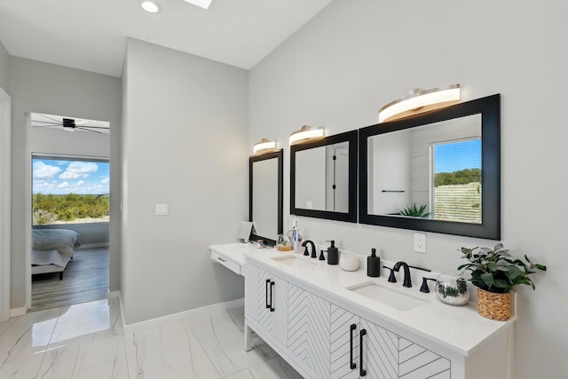 full bathroom featuring baseboards, a wealth of natural light, a sink, and marble finish floor