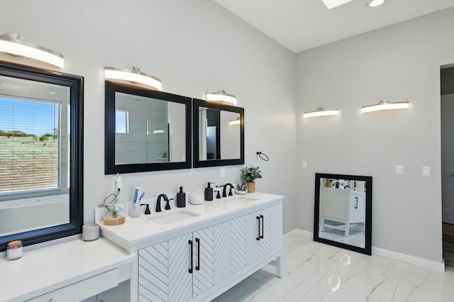 bathroom featuring double vanity, baseboards, a sink, and marble finish floor