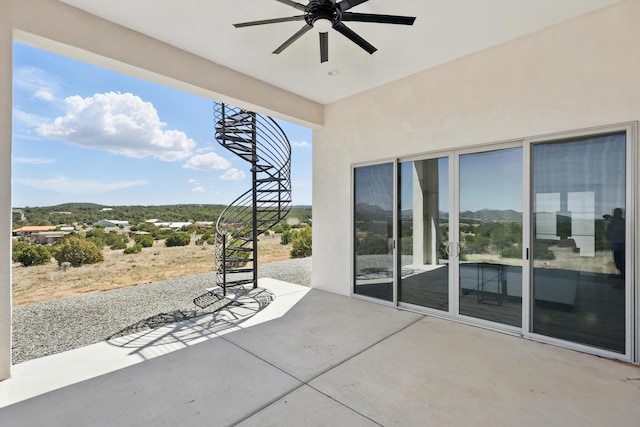 view of patio with ceiling fan and a mountain view