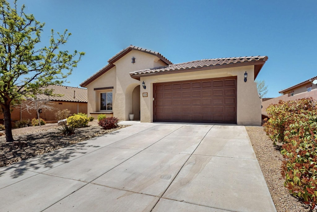 416 Paseo Vista Loop NE, Rio Rancho, NM 87124 - mediterranean / spanish home with concrete driveway, stucco siding, a garage, and a tile roof