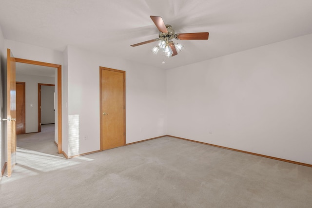 unfurnished room featuring baseboards, a ceiling fan, and light colored carpet