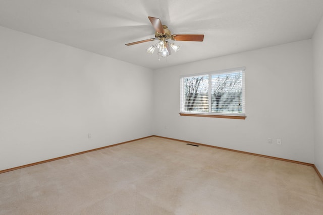 unfurnished room featuring a ceiling fan, visible vents, light carpet, and baseboards