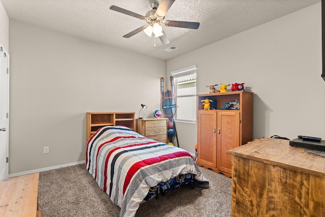 bedroom featuring visible vents, ceiling fan, baseboards, and a textured ceiling