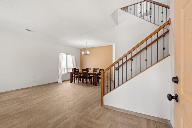 10532 Box Canyon Pl NW, Albuquerque, NM 87114 - entryway featuring a chandelier, stairs, wood finished floors, and baseboards