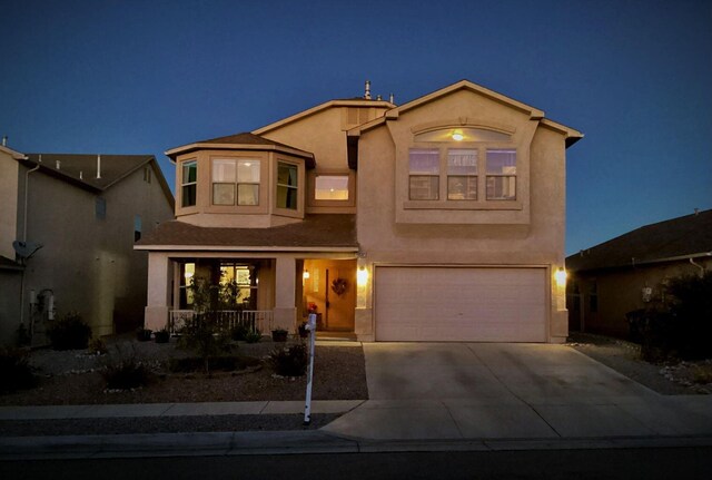 10532 Box Canyon Pl NW, Albuquerque, NM 87114 - view of front facade featuring covered porch, stucco siding, a garage, and concrete driveway