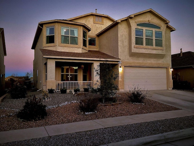 10532 Box Canyon Pl NW, Albuquerque, NM 87114 - view of front facade with a porch, stucco siding, an attached garage, and concrete driveway