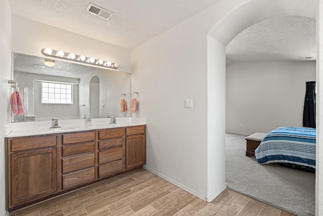 10532 Box Canyon Pl NW, Albuquerque, NM 87114 - full bath with a textured ceiling, ensuite bathroom, wood finished floors, baseboards, and double vanity