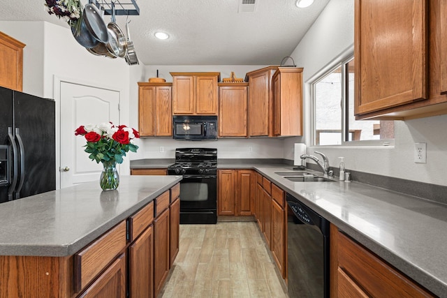 10532 Box Canyon Pl NW, Albuquerque, NM 87114 - kitchen featuring black appliances, a sink, brown cabinetry, a textured ceiling, and recessed lighting