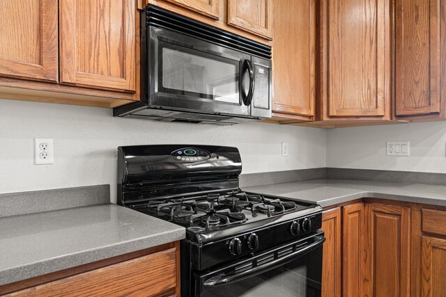 10532 Box Canyon Pl NW, Albuquerque, NM 87114 - kitchen featuring black appliances, brown cabinetry, and dark countertops