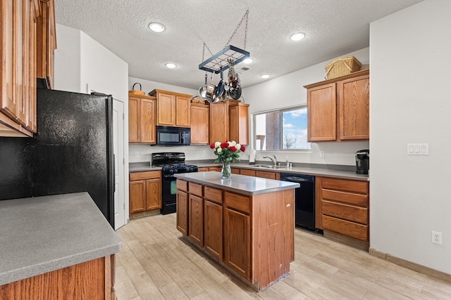 10532 Box Canyon Pl NW, Albuquerque, NM 87114 - kitchen with black appliances, a sink, a center island, light wood-style floors, and a textured ceiling