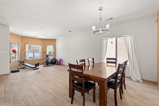 10532 Box Canyon Pl NW, Albuquerque, NM 87114 - dining room featuring a textured ceiling, light wood-style floors, and a chandelier