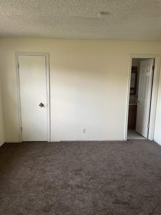 unfurnished bedroom featuring a textured ceiling and carpet