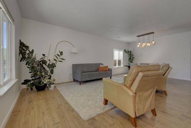 1807 Avenida Comunidad, Rio Rancho, NM 87124 - living area with light wood finished floors, a chandelier, and baseboards
