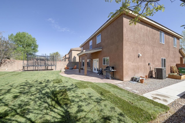 1807 Avenida Comunidad, Rio Rancho, NM 87124 - back of property with a trampoline, stucco siding, a patio, and cooling unit