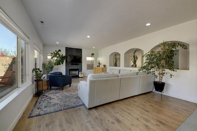 1807 Avenida Comunidad, Rio Rancho, NM 87124 - living room with a large fireplace, wood finished floors, recessed lighting, and baseboards