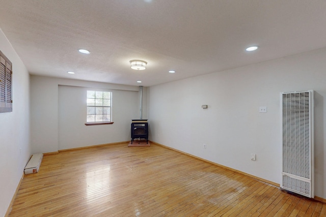 1647 Atrisco Dr SW, Albuquerque, NM 87105 - unfurnished room with a heating unit, a wood stove, light wood finished floors, recessed lighting, and baseboard heating