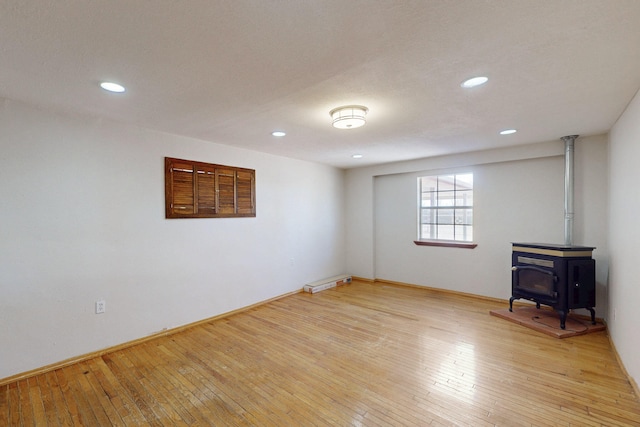 1647 Atrisco Dr SW, Albuquerque, NM 87105 - below grade area with light wood-type flooring, a wood stove, recessed lighting, and baseboards