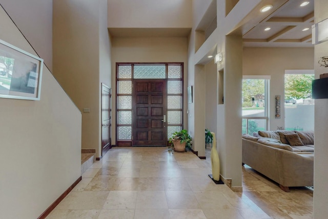 foyer entrance with beamed ceiling, a towering ceiling, recessed lighting, coffered ceiling, and baseboards