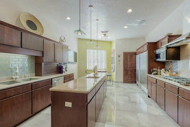 kitchen featuring tasteful backsplash, a center island, a sink, and appliances with stainless steel finishes