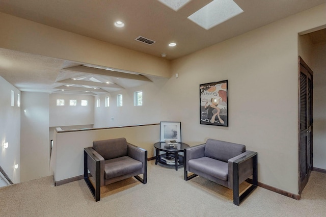 living area featuring a skylight, baseboards, carpet, and recessed lighting